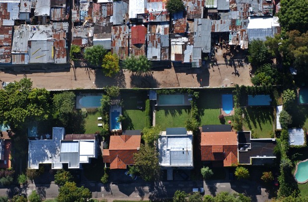 A birds' eye view of slum La Caval, top, and a gated suburban community, below, in Buenos Aires suburbs, April 12, 2003, underscores the glaring divide between rich and poor in Argentina today. La Cava's jumble of ramshackle plywood home have grown swiftly during the 5-year-old recession, outpacing the growth of middle-class suburbia. (AP Photo/Natacha Pisarenko)